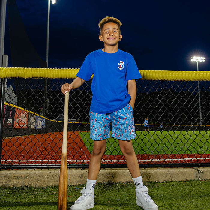 Youth model wearing red, white & blue youth shorts with “Firework Flyball” design