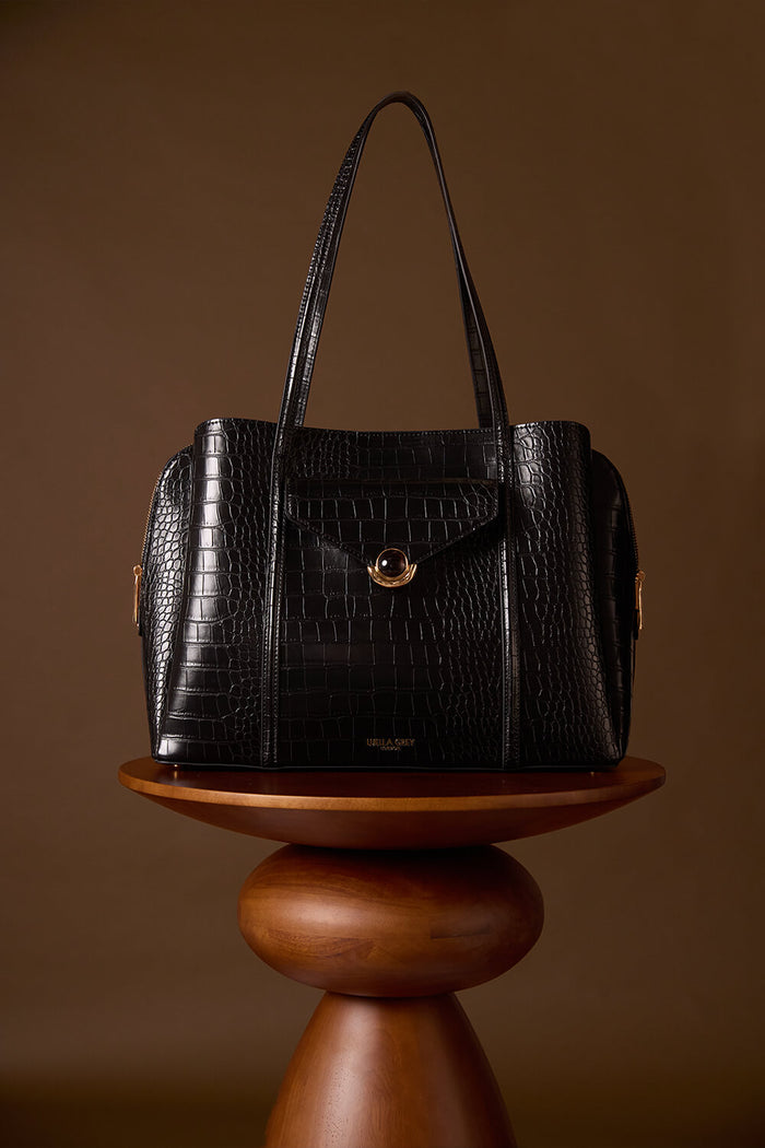 Francois Black Crocodile print faux leather Laptop Tote displayed on a brown wooden plinth