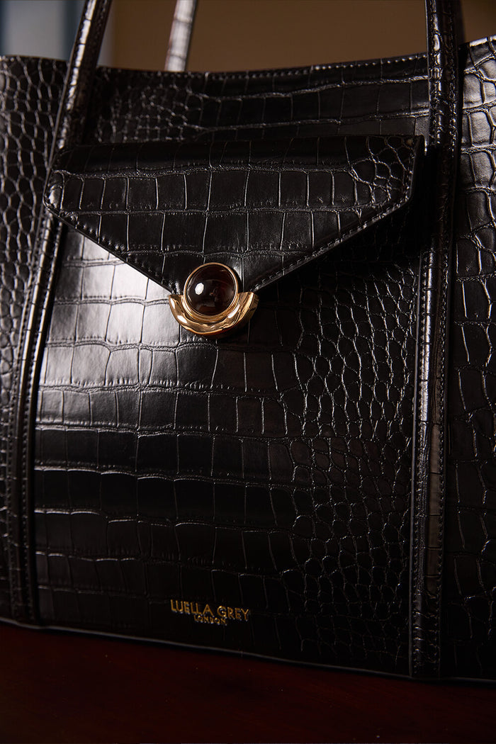 Close up of the front of Francois Black Crocodile print faux leather Laptop Tote focusing on the Molten Metal Crystal Palace Clasp closure on the front slip in pocket