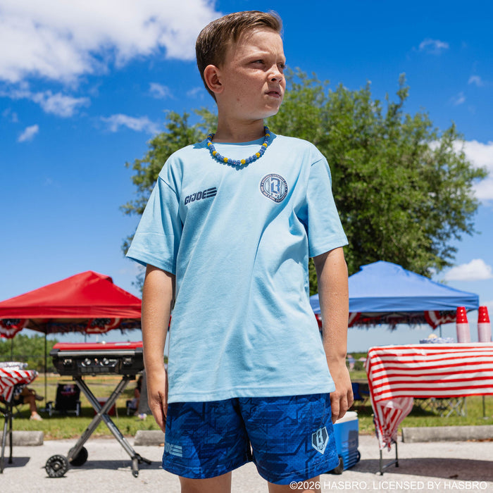Youth model wearing blue youth shorts with “G.I. Joe Star” design