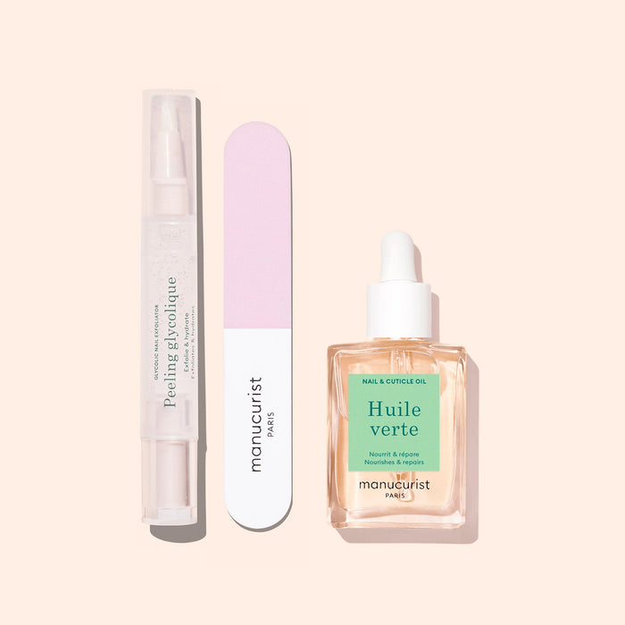 Three Glow Routine manicure essentials by Manucurist on a beige background: a clear peeling gel pen, a pink and white nail file, and a dropper bottle of cuticle oil for glossy nails and expert care.