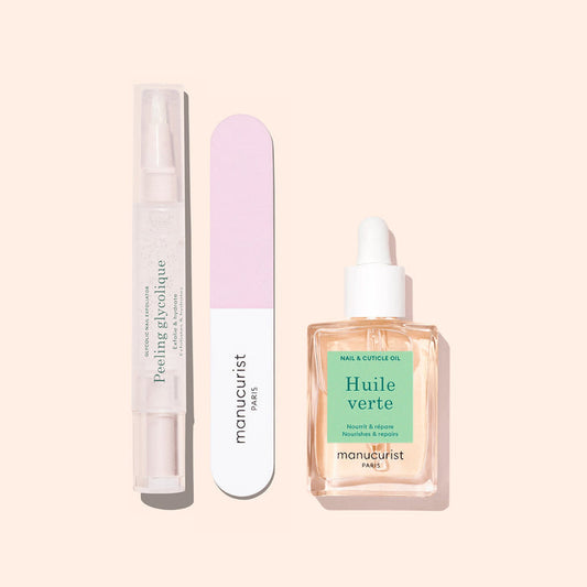 Three Glow Routine manicure essentials by Manucurist on a beige background: a clear peeling gel pen, a pink and white nail file, and a dropper bottle of cuticle oil for glossy nails and expert care.