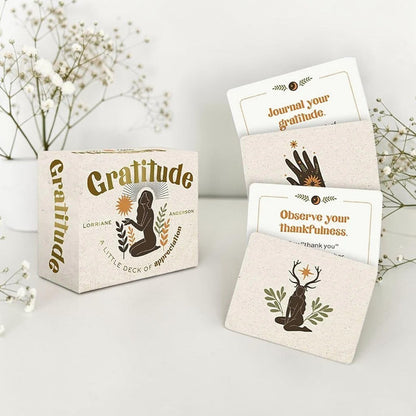 Gratitude card set with cards and packaging on a light surface with flowers in the background