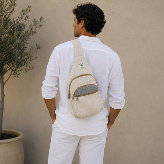 Man wearing a beige crossbody bag against a beige wall
