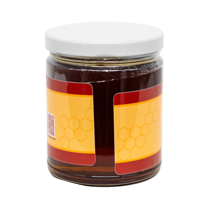 Jar of honey with a white lid on a white background