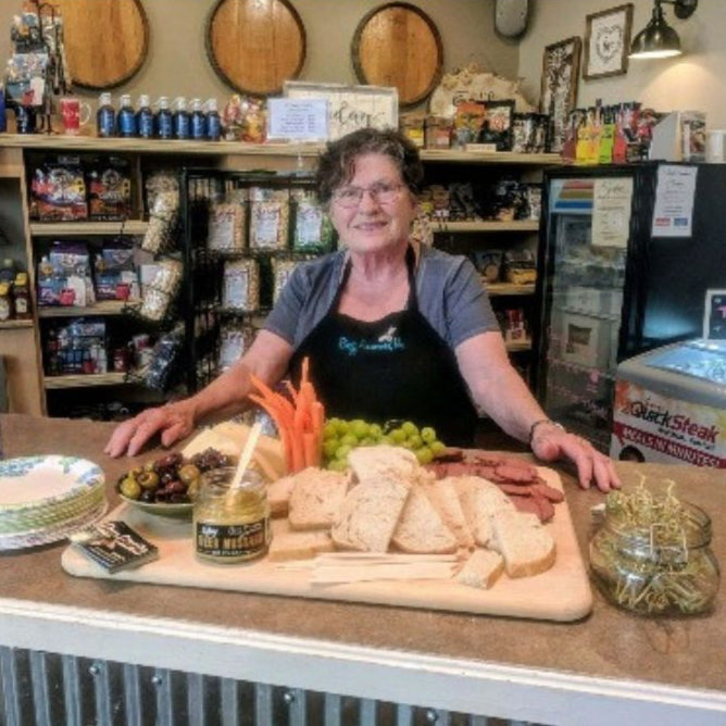 Betty, CEO Of Buzz Savories, standing next to her product.