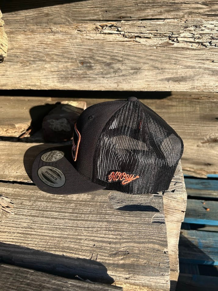 Hooey x Oklahoma State University Cowboys Black 6 panel snapback trucker cap with mesh back. Features a Cowboys patch on front and a small Hooey logo on side. Side view outside photo.
