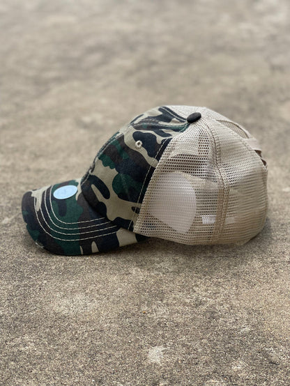 Camo front and tan mesh back distressed crisscross ponytail cap. The back has elastic crisscrossing bands and a adjustable Velcro back for a truly adjustable fit for your ponytails or buns. Side View