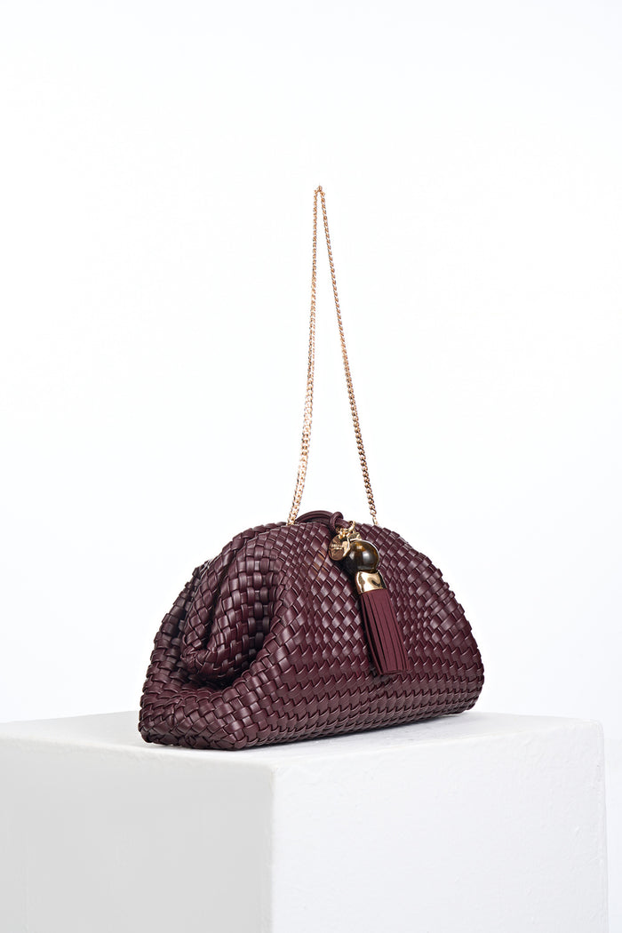 Side view of Indigo Black Cherry woven faux leather Oversized Clutch showing the gold clasp closure and detachable gold metal chain shoulder strap