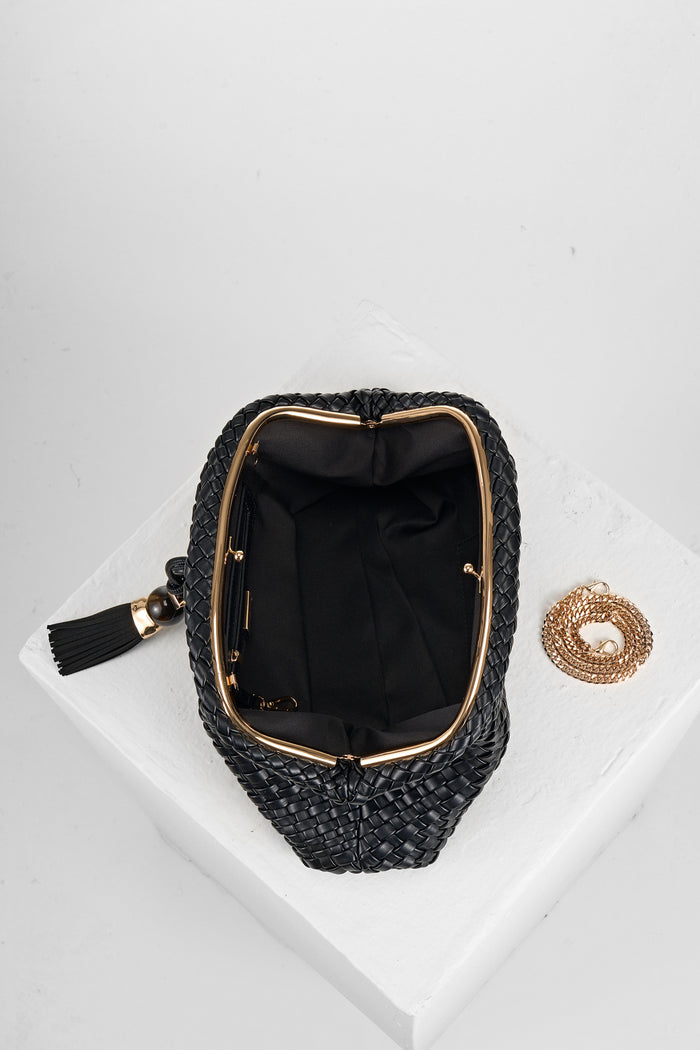 Overhead view of Indigo Black woven faux leather Oversized Clutch open showing the inside and covered gold frame clasp opening and the gold metal chain next to the bag