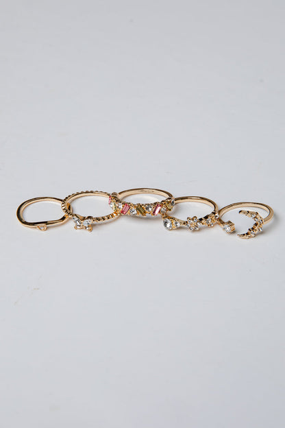 Set of gold rings with various designs on a light gray background
