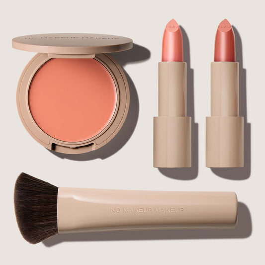No Makeup Makeup – Makeup set with peach blush & lip color, peach Creme Classic Lipsticks, and brush on a light background, natural minimal makeup