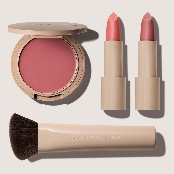 No Makeup Makeup – Makeup set with pink blush & lip color, pink Creme Classic Lipsticks, and brush on a light background, natural minimal makeup