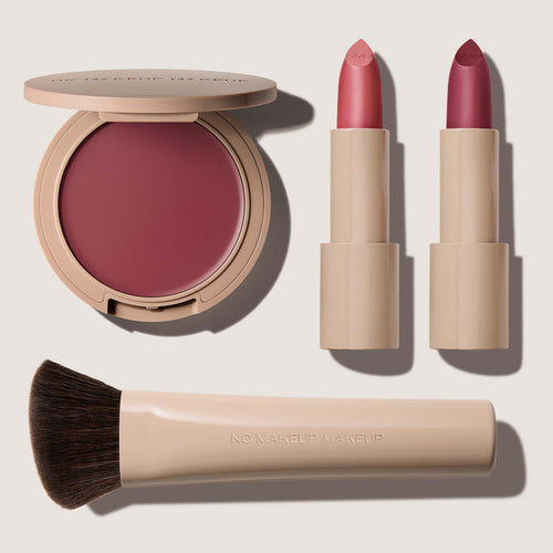 No Makeup Makeup – Makeup set with plum blush & lip color, plum Creme Classic Lipsticks, and brush on a light background, natural minimal makeup