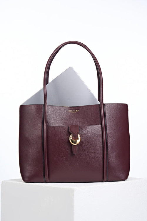 Front of Lilibet Black Cherry faux leather Laptop Tote with a laptop in the top showing molten metal Cannon Street Clasp closure on front slip-in pocket