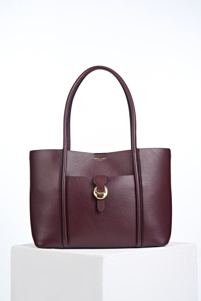 Front of Lilibet Black Cherry faux leather Laptop Tote showing molten metal Cannon Street Clasp closure on front slip-in pocket