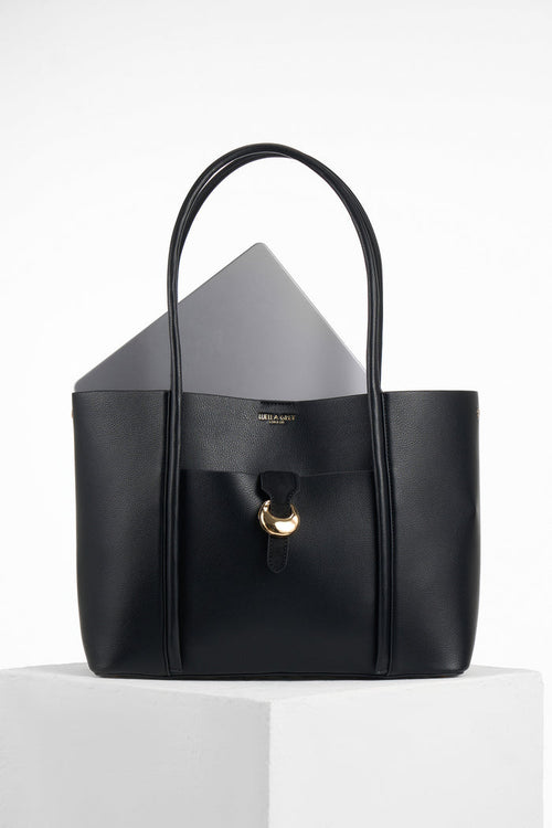 Front of Lilibet Black faux leather Laptop Tote with a laptop in the top showing molten metal Cannon Street Clasp closure on front slip-in pocket
