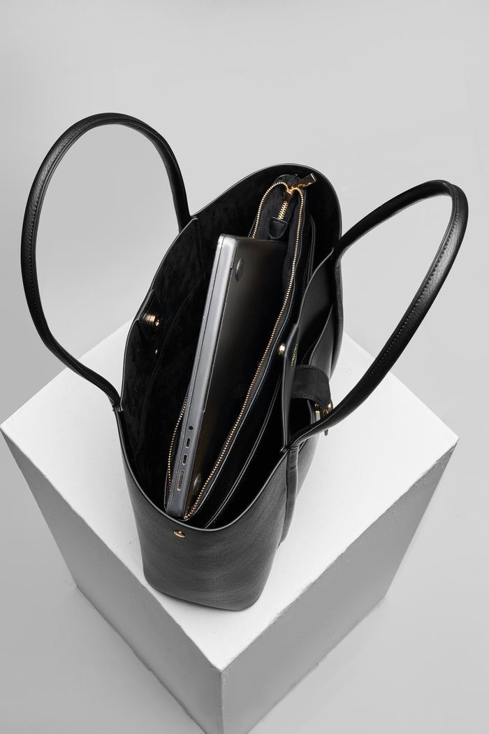 Overhead view of Lilibet Black faux leather Laptop Tote showing the detachable top zip laptop pocket and faux suede lining