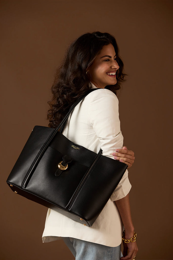 Female model holding Lilibet Black Laptop Tote over her shoulder using the two shoulder straps
