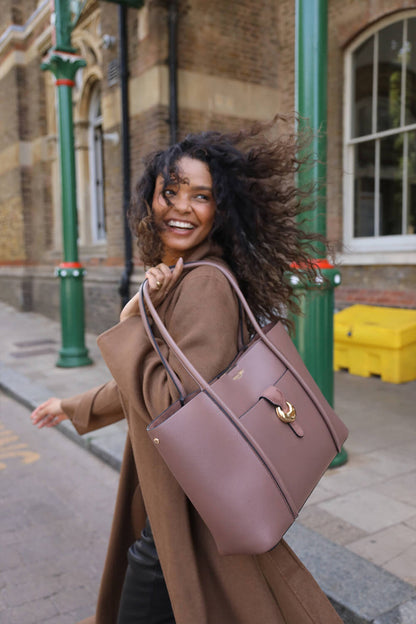 Female model holding Lilibet Fawn faux leather Laptop Tote over her shoulder by the shoulder straps