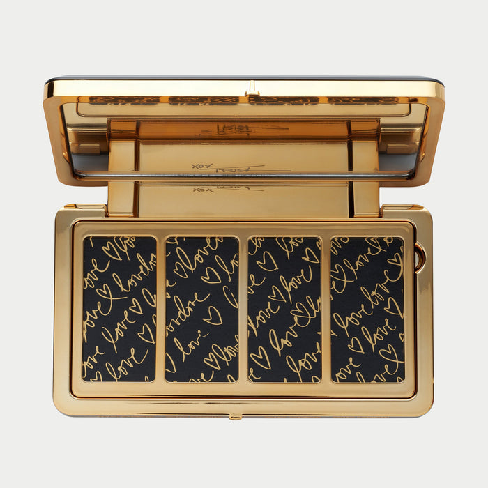 Makeup palette with gold border and black background with gold text on a white background