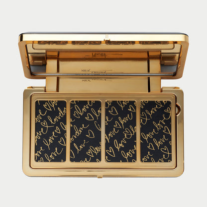 Makeup palette with gold border and black background with gold text on a white background