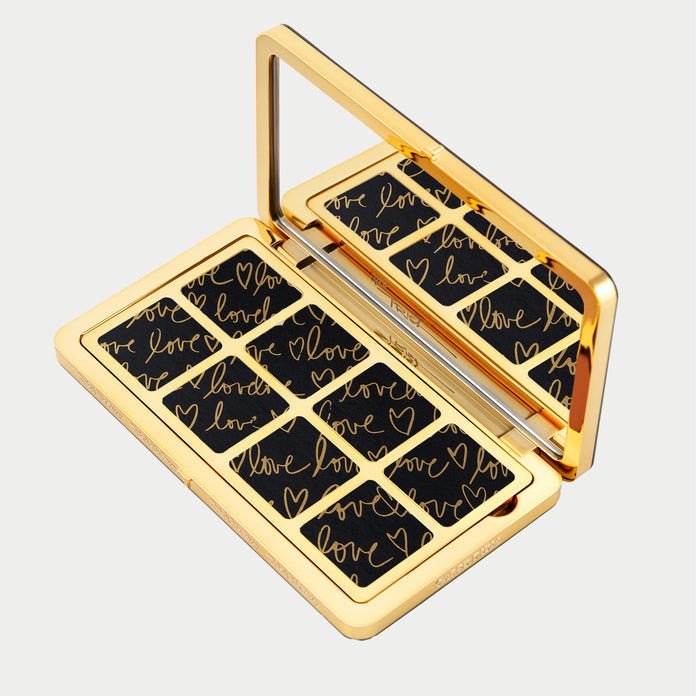 Compact mirror with 'love' and heart designs on a black background