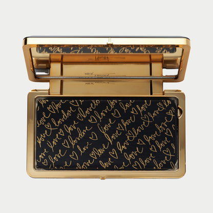 Gold and black clutch with 'I love you' text on a light gray background