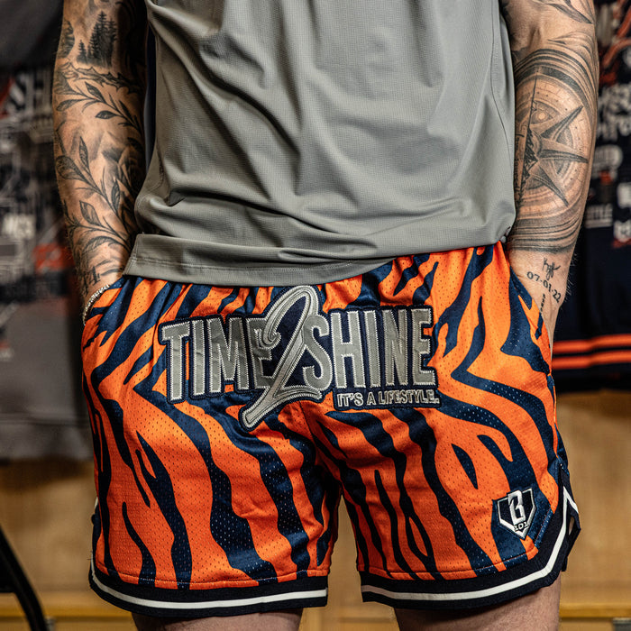 Adult model wearing orange Max Clark Tiger Court shorts