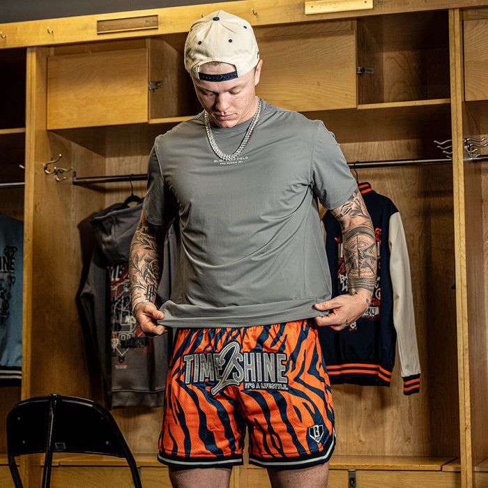 Adult model wearing orange Max Clark Tiger Court shorts