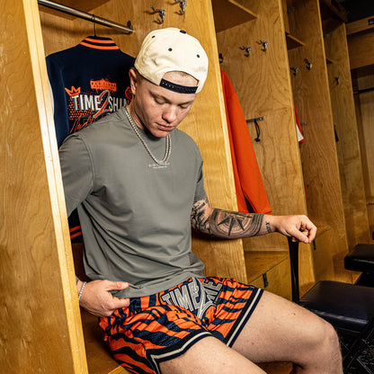 Adult model wearing orange Max Clark Tiger Court shorts
