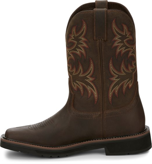 A instep side view of a pair of Justin Men's Driller Brown Square Toe Work Boots with a decorative stitch pattern in Yellow and Orange on the shaft.