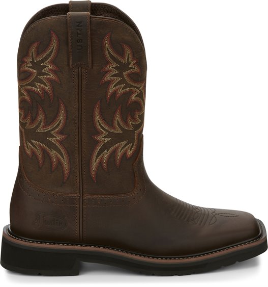 A side view of a pair of Justin Men's Driller Brown Square Toe Work Boots with a decorative stitch pattern in Yellow and Orange on the shaft.