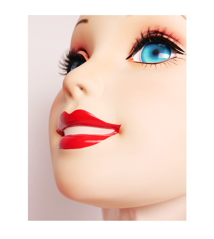 Pink latex female doll mask with gag and hood, InTheMask by MOLIS, featuring detailed facial features and adjustable fit.