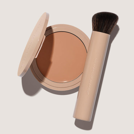 An open FlexShade Foundation by No Makeup Makeup compact in Almond and a brush with the Oprah Daily Beauty O-Wards 2024 seal