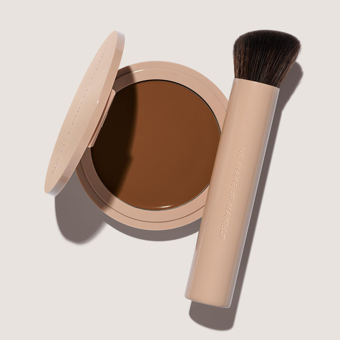 An open FlexShade Foundation by No Makeup Makeup compact in Dark and a brush with the Oprah Daily Beauty O-Wards 2024 seal