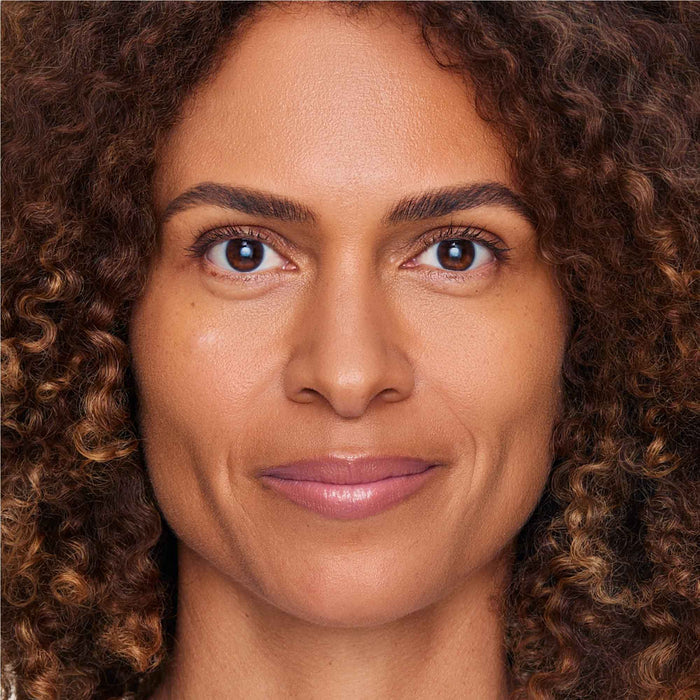 An image of a woman wearing FlexShade Foundation by No Makeup Makeup in Tan