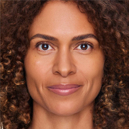 An image of a woman wearing FlexShade Foundation by No Makeup Makeup in Tan