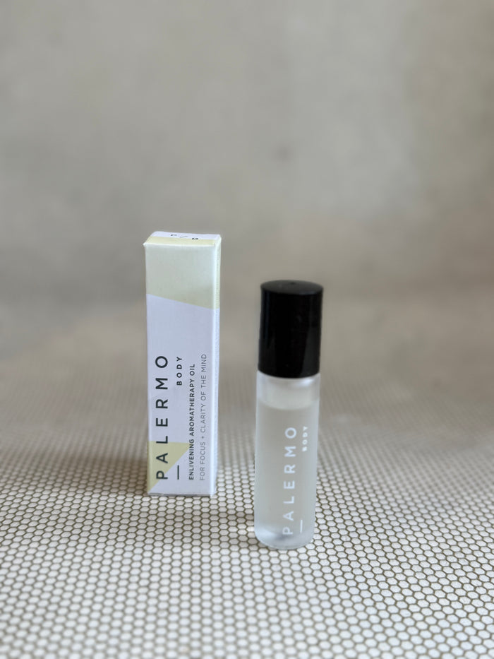 Roll-on bottle of Palermo body enlivening aromatherapy oil with small white and yellow box.