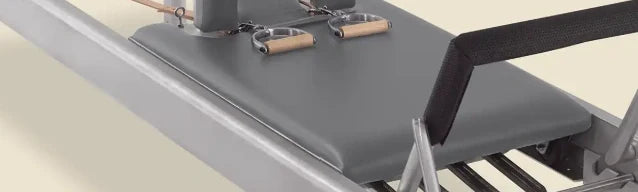 Greystone pre-stitched upholstery fitted on a Gratz Pilates reformer carriage with handles and straps.