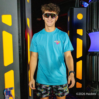 Person wearing a blue shirt and black shorts with colorful 'Nerf x BL101' logo pattern, standing in front of a black and yellow background