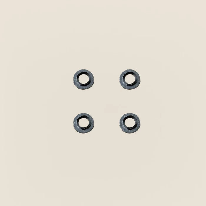 Four dark metal Gardner springs and flat washers for a Pilates reformer guide wheel.