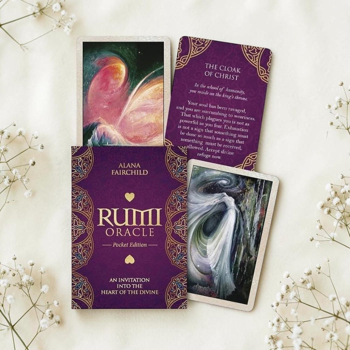 Rumi Oracle cards with purple covers and white flowers on a light background