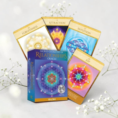 Sacred Geometry of Relationships Oracle cards on a light background with flowers.