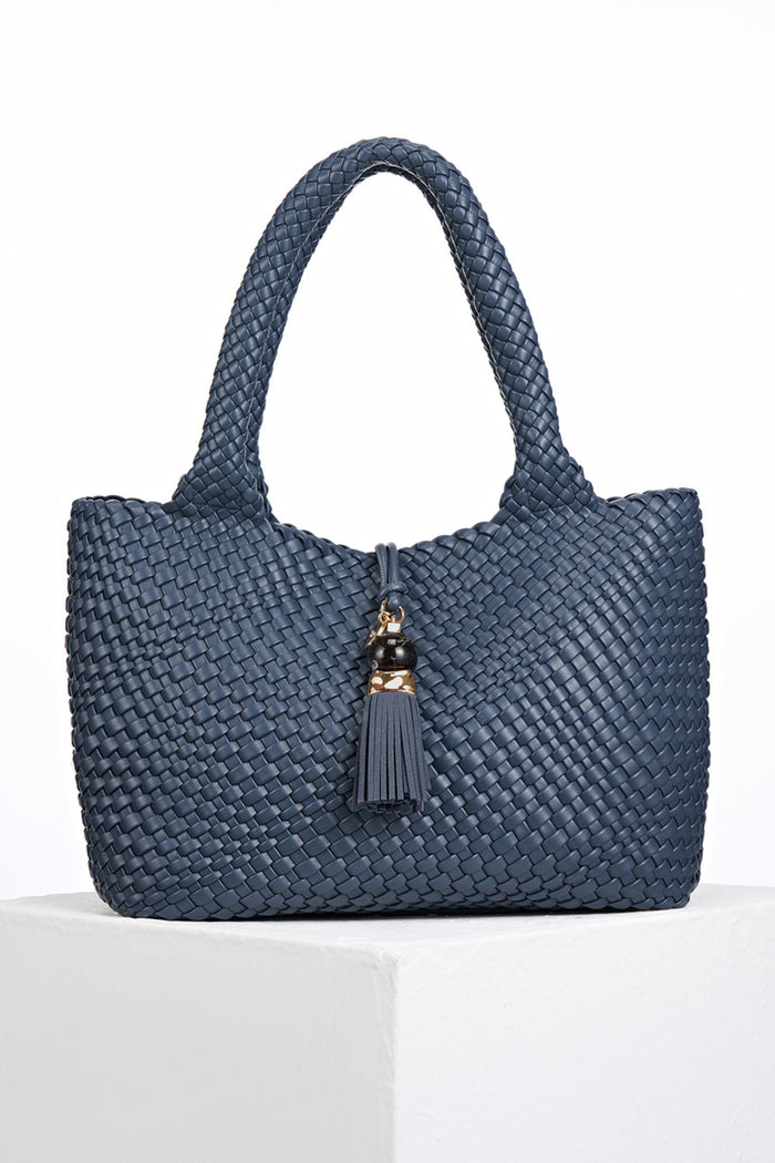 Front view of Saskia Denim Blue faux leather Woven Tote with Thames Tassel closure detail
