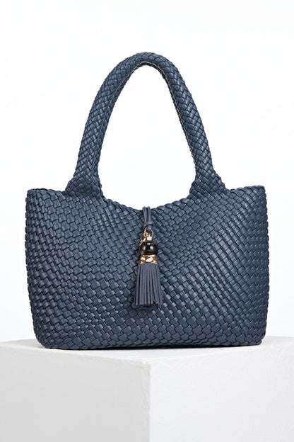 Front view of Saskia Denim Blue faux leather Woven Tote with Thames Tassel closure detail