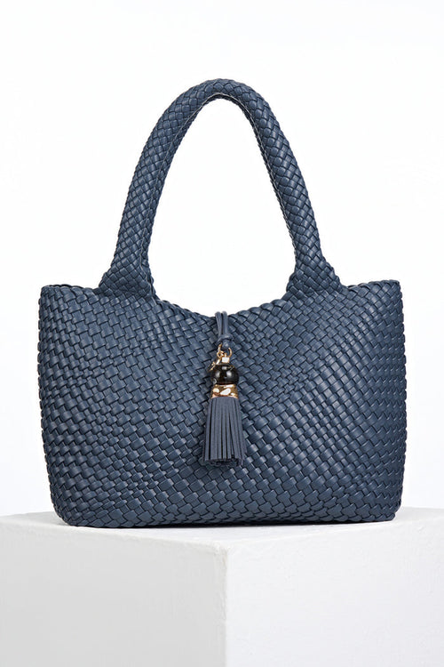 Front view of Saskia Denim Blue faux leather Woven Tote with Thames Tassel closure detail