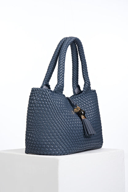Side view of Saskia Denim Blue faux leather Woven Tote with Thames Tassel closure detail