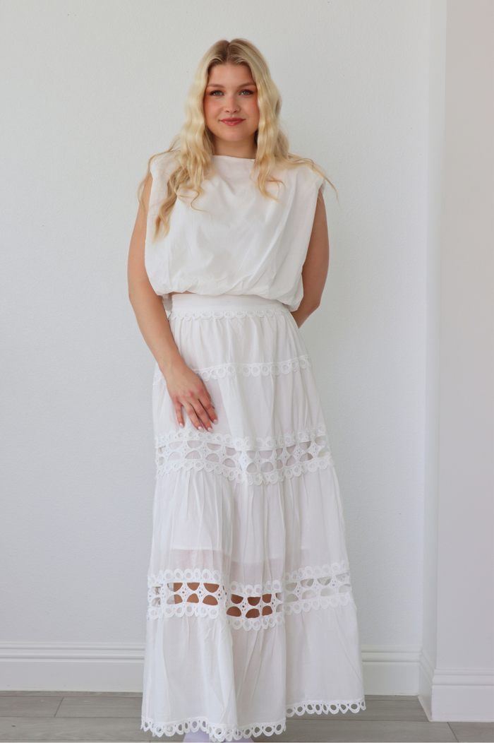 girl wearing matching white set; long skirt and tank top