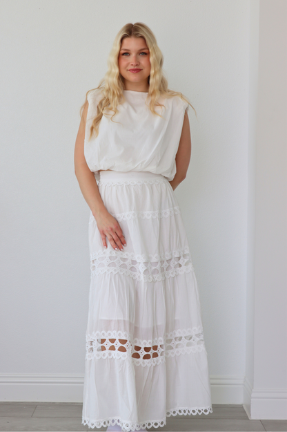girl wearing matching white set; long skirt and tank top
